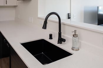 a kitchen sink with a black faucet